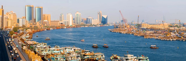 Traditional abra boats crossing Dubai Creek with historical buildings in the background