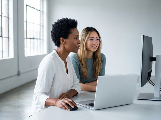 Two people collaborating in an office, illustrating improved team dynamics through self-awareness.